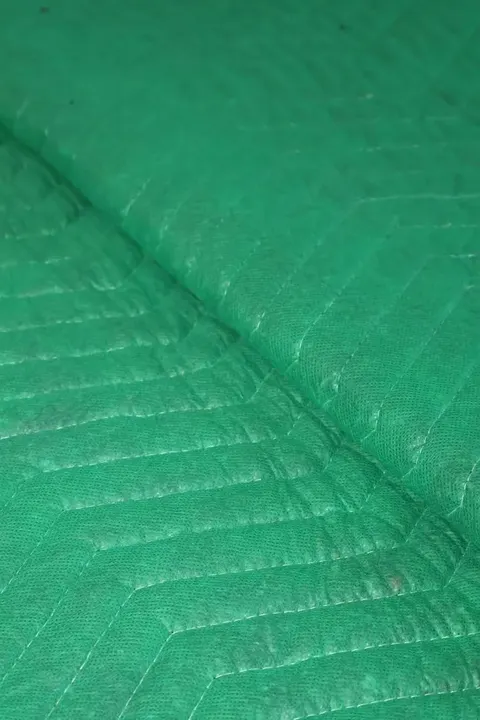 Green cotton moving pad folded edge close-up