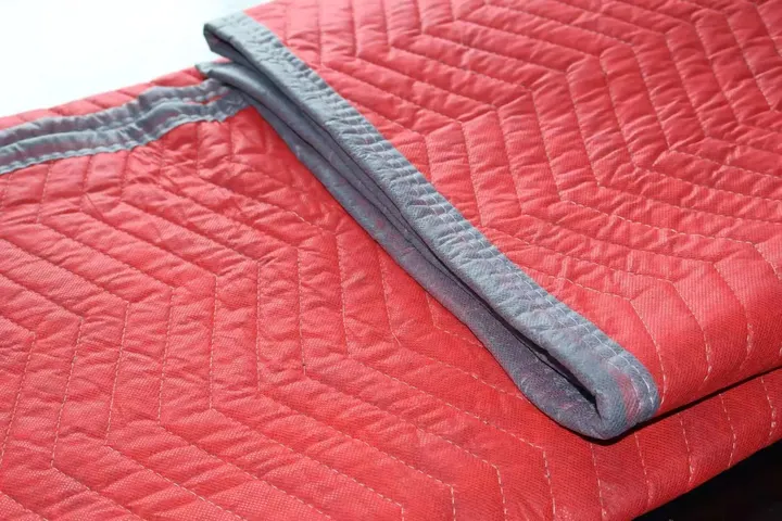Folded red cotton moving pad with grey trim