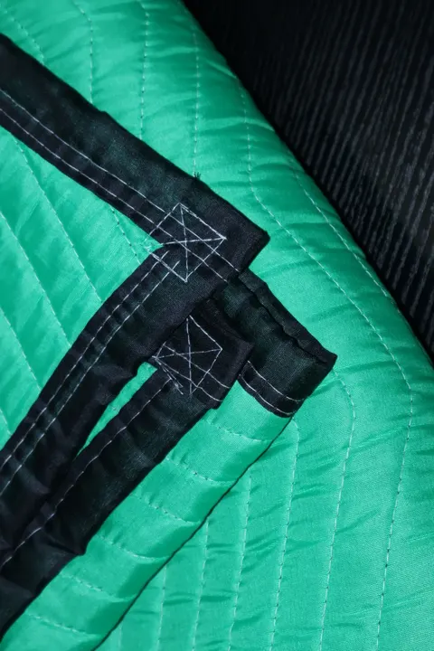 Green polyester moving pad quilted stitching close-up