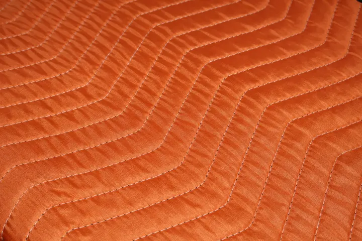 Orange polyester moving pad quilted stitching close-up
