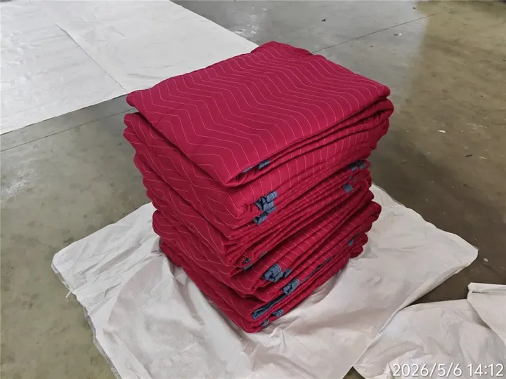 Stack of red polyester moving pads in a warehouse