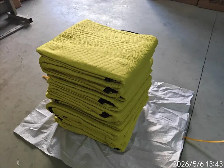 Stack of yellow polyester moving pads in a warehouse